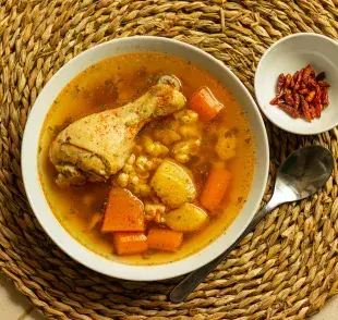 Caldo de pollo sobre un mantel. Foto: Pexels/Istvan Szabo