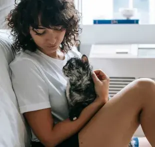 Mujer argentina acariciando a su gato. Foto: pexels/Sam Lion