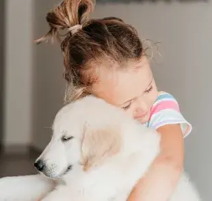 Niña con su perro de terapia el cual le ofrece beneficios como la mejora del estado de ánimo. Foto: Pexels/mawa_ts